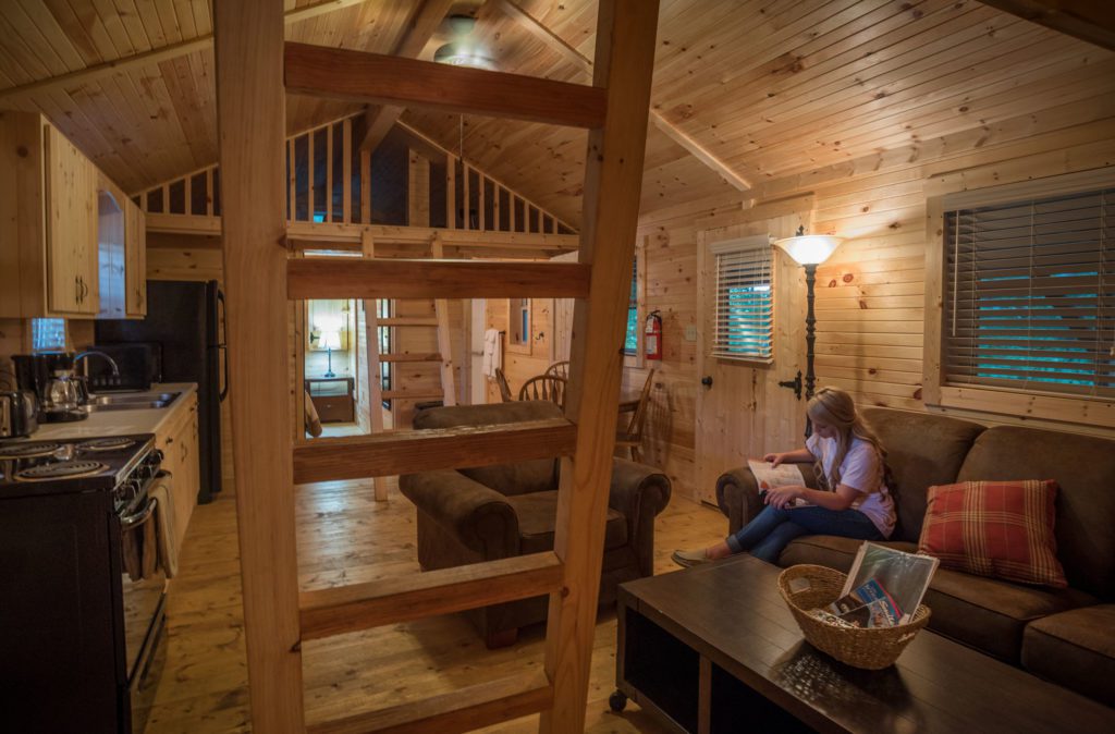 Woman reading on couch inside cabin