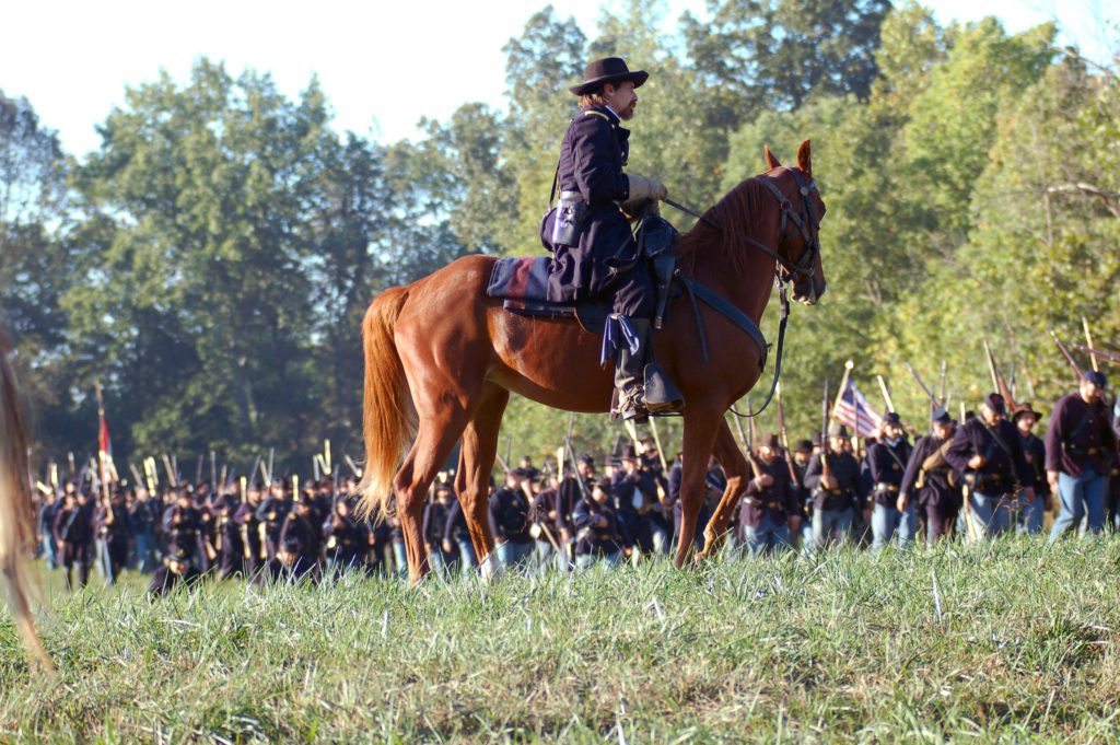 Union soldier sits atop horse in field during Civil War reenactment