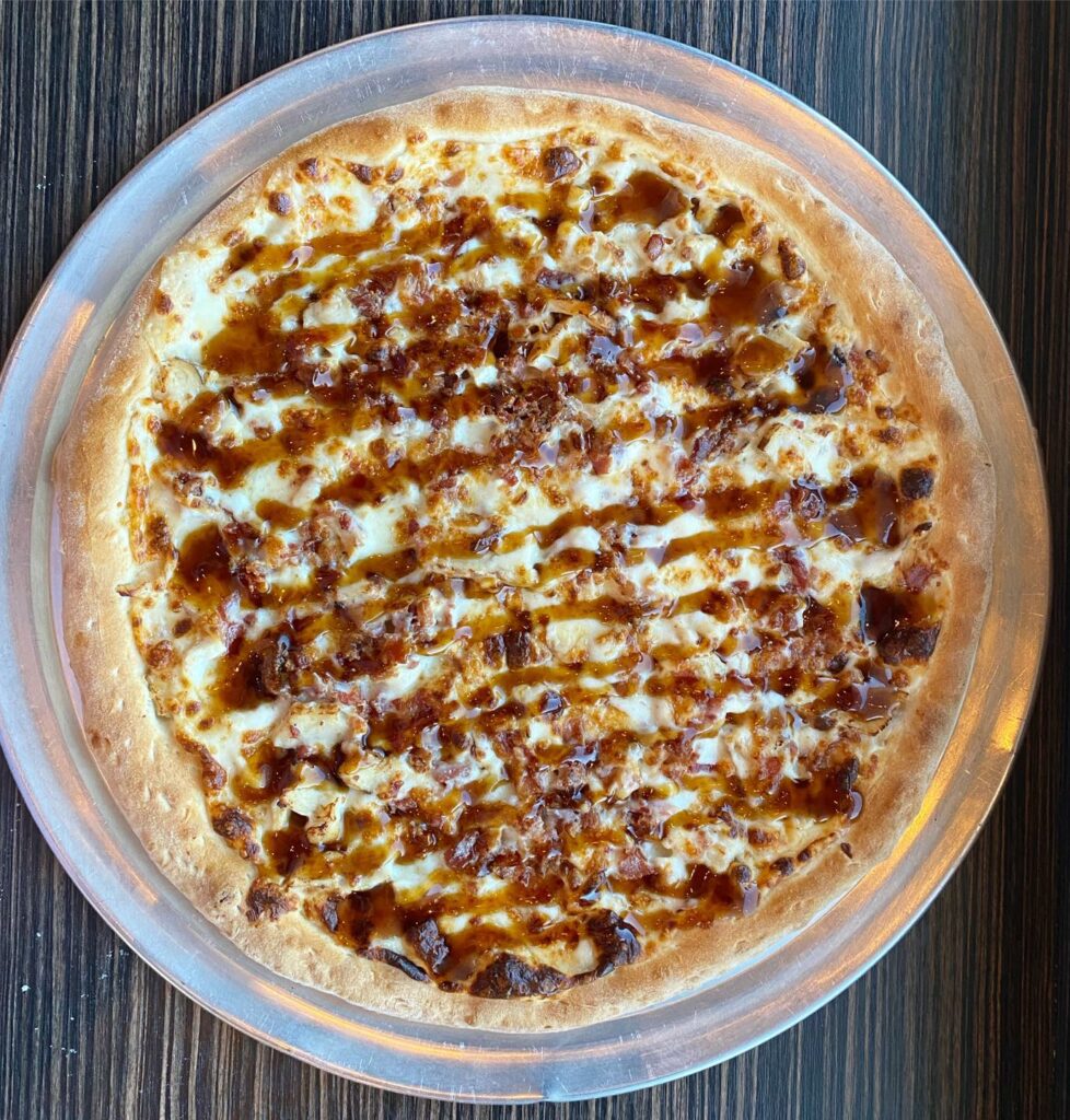 The Tipsy Chicken Pizza which is Beer Cheese base, Chicken, Bacon, & Bourbon Glaze!
