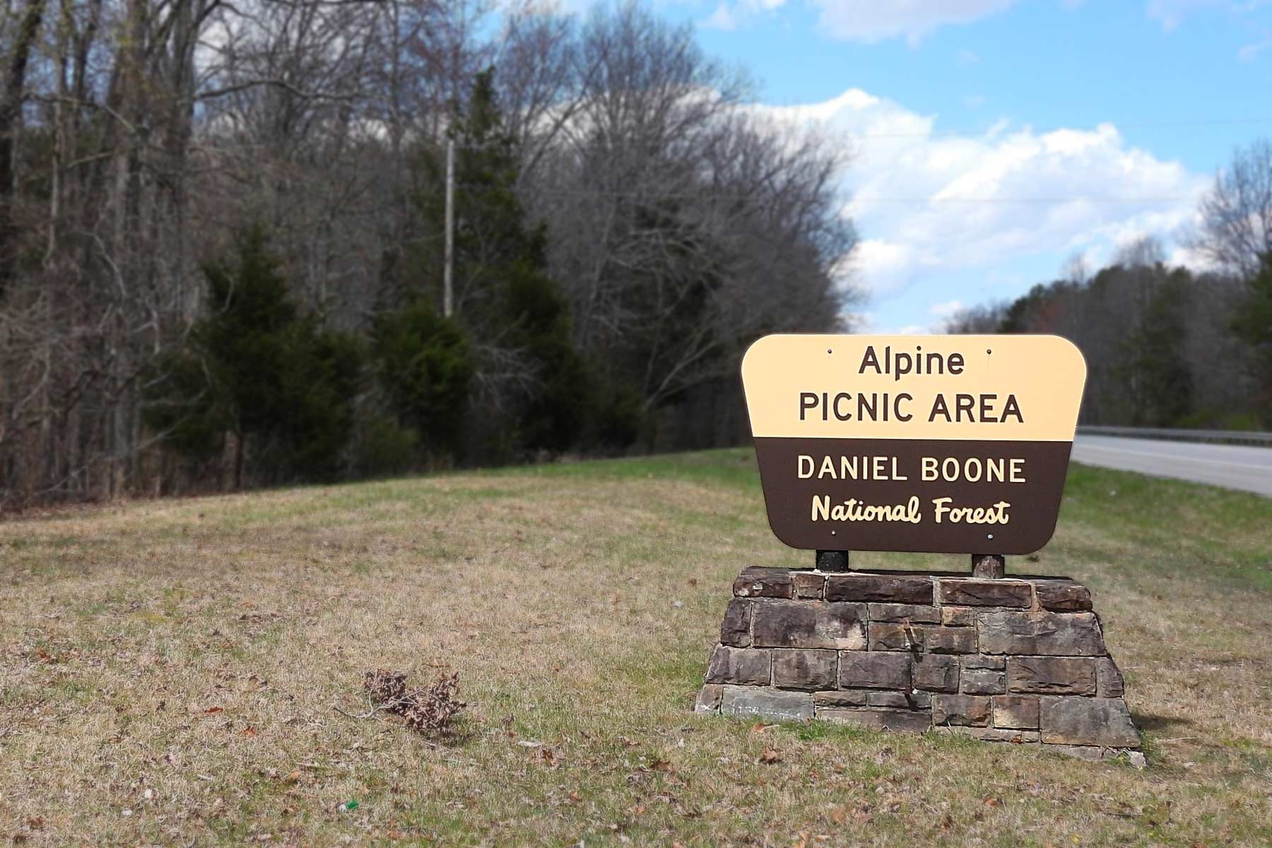 Field and woods with sign that ready Alpine Picnic Area Daniel Boone National Forest.