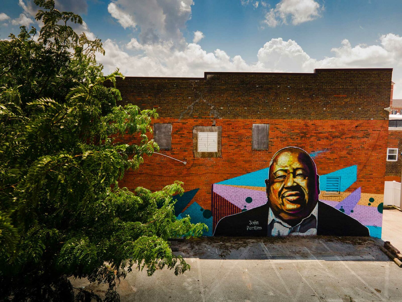 Brick building with large mural portrait of a man.