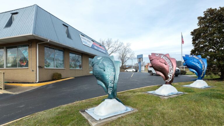 Exterior of Visitor Center building with large fish sculptures in front.