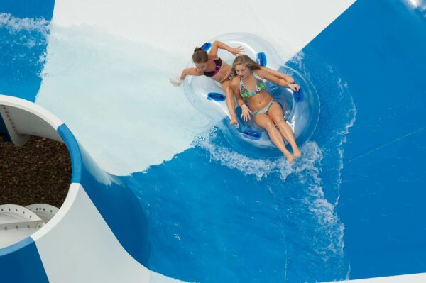 Girls on raft on water slide.